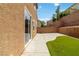Enclosed backyard features concrete patio, artificial turf, and brick retaining wall at 7345 Chesapeake Cove St, Las Vegas, NV 89166