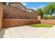 Enclosed backyard features concrete patio, artificial turf, and brick retaining wall at 7345 Chesapeake Cove St, Las Vegas, NV 89166
