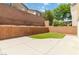 Enclosed backyard features concrete patio, artificial turf, and brick retaining wall at 7345 Chesapeake Cove St, Las Vegas, NV 89166