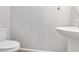 Clean powder room features a pedestal sink, toilet and accent mirror at 7345 Chesapeake Cove St, Las Vegas, NV 89166