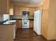 Bright kitchen with wood cabinets, laminate floors, and white appliances at 8708 Gateway Glen Dr, Las Vegas, NV 89178