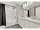 Bright bathroom featuring double sinks with a white vanity and a shower over tub with subway tile surround at 872 Pointe Arbor St, Henderson, NV 89011