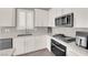 Updated kitchen has stainless steel appliances and white cabinets and gray backsplash at 872 Pointe Arbor St, Henderson, NV 89011