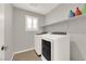 Laundry room with a modern washer and dryer and white shelves at 872 Pointe Arbor St, Henderson, NV 89011