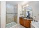Bathroom features a glass-enclosed shower, granite vanity, and decorative mirror at 9032 Retro Ct, Las Vegas, NV 89149