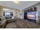 Cozy living room features wood floors, a large sectional sofa, and a modern entertainment center with a TV at 9032 Retro Ct, Las Vegas, NV 89149