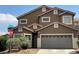 A tan two-story home features a two-car garage and desert landscaping at 9145 Sunken Meadow Ave, Las Vegas, NV 89178