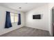 Neutral bedroom with blue curtains, a wall-mounted television and bright white walls at 9333 Leaping Deer Pl # 102, Las Vegas, NV 89178