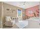 Bedroom with soft pink accents, a cozy chair, and crib at 9869 Lime Tree St, Las Vegas, NV 89178