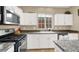 Modern kitchen equipped with stainless steel appliances, white cabinetry, and granite countertops at 9869 Lime Tree St, Las Vegas, NV 89178