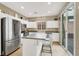 Well-lit kitchen featuring stainless steel appliances, a large island, and access to the outdoor patio at 9869 Lime Tree St, Las Vegas, NV 89178
