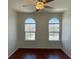 A bright bedroom with two windows, wood floors and a ceiling fan at 10052 Baystone St, Las Vegas, NV 89141