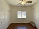 Bedroom features wood-look floors, fan, window, and double closets, adding functionality and charm at 10052 Baystone St, Las Vegas, NV 89141