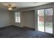 Comfortable bedroom with neutral carpet, ceiling fan, and a sliding door leading to the backyard at 10052 Baystone St, Las Vegas, NV 89141
