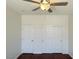 This bedroom features wood flooring, a ceiling fan and a closet at 10052 Baystone St, Las Vegas, NV 89141