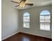 A cozy bedroom featuring beautiful wood floors, two windows and a ceiling fan at 10052 Baystone St, Las Vegas, NV 89141