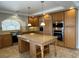 Well-equipped kitchen features custom cabinets, granite countertops, stainless appliances, and central island cooktop at 10052 Baystone St, Las Vegas, NV 89141