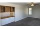 Cozy living room with gray carpet, ceiling fan, wet bar, and natural light through a window at 10052 Baystone St, Las Vegas, NV 89141
