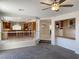Open-concept living room featuring plush gray carpet, ceiling fan, and a convenient bar area leading to the kitchen at 10052 Baystone St, Las Vegas, NV 89141