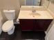 Bathroom with a toilet, sink with cabinet, and sleek tile flooring at 10118 Farmington Hall Ct, Las Vegas, NV 89129