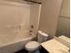 Full bathroom with a tub-shower combination, updated fixtures, and neutral tile at 10118 Farmington Hall Ct, Las Vegas, NV 89129