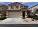 Two-story home featuring tan siding, desert landscaping, and an attached two-car garage at 10118 Farmington Hall Ct, Las Vegas, NV 89129