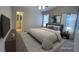 Bright bedroom with neutral tones, vaulted ceiling, and ensuite bathroom access, virtually staged at 10321 Birch Bluff Ln, Las Vegas, NV 89145