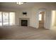 Cozy living room features a fireplace, ceiling fan, and sliding door access to the outdoor patio area at 10321 Birch Bluff Ln, Las Vegas, NV 89145