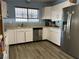 Bright kitchen featuring white cabinets, stainless steel appliances, and wood-look floors at 105 Huntly Rd, Las Vegas, NV 89145