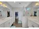 Modern bathroom with double sinks, a glass-enclosed shower, and a walk-in closet at 1120 Via Della Curia, Henderson, NV 89011