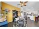 Yellow dining area featuring a round table, dark cabinets, and seamless flow into the kitchen at 1120 Via Della Curia, Henderson, NV 89011