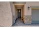 Inviting entryway with a decorative front door, brick accents, and a bench, offering curb appeal at 1120 Via Della Curia, Henderson, NV 89011