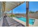 Backyard view of a pool and spa, with a covered patio, lush greenery and beautiful landscaping at 1120 Via Della Curia, Henderson, NV 89011