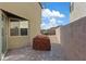 A backyard featuring a brick patio next to a narrow strip of gravel and a covered grill at 1266 Smokey Valley Ln, Henderson, NV 89002