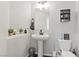 Neutral half bath featuring a pedestal sink, decorative shelves and a framed mirror at 1266 Smokey Valley Ln, Henderson, NV 89002