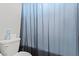 Powder room with a blue shower curtain, a toilet, and white walls at 1266 Smokey Valley Ln, Henderson, NV 89002