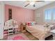 Charming bedroom featuring pink accents, stylish decor, and ample natural light creating a cozy and inviting space at 1266 Smokey Valley Ln, Henderson, NV 89002