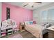 Cozy pink bedroom featuring a white iron bed, a vanity and plantation shutters at 1266 Smokey Valley Ln, Henderson, NV 89002