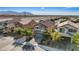 A two-story home featuring a well-manicured front lawn with green trees and a paved driveway at 1266 Smokey Valley Ln, Henderson, NV 89002