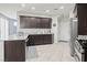 Spacious kitchen featuring dark cabinets, granite countertops, and stainless steel appliances at 1266 Smokey Valley Ln, Henderson, NV 89002