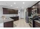 Well-lit kitchen boasts granite counters, stainless steel appliances, and dark wood cabinetry for a modern feel at 1266 Smokey Valley Ln, Henderson, NV 89002