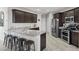 Stylish kitchen boasts dark wood cabinetry, stainless steel appliances, and a sleek breakfast bar with bar stool seating at 1266 Smokey Valley Ln, Henderson, NV 89002