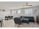 Bright living room with a large sectional sofa, tile flooring, and view to backyard at 1266 Smokey Valley Ln, Henderson, NV 89002