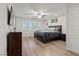 Spacious main bedroom with fan, TV, shutters on windows, neutral walls and wood-look floors at 1266 Smokey Valley Ln, Henderson, NV 89002