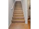 Staircase with wood-look flooring and white trim, leading to the upper level of the home, enhanced by natural light at 1266 Smokey Valley Ln, Henderson, NV 89002