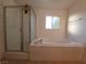 Bright bathroom with a tub, a tiled shower, and a window with natural light at 165 W Alma Ave, Overton, NV 89040