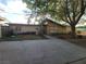 Home exterior view highlighting a front yard, driveway, and mature trees at 165 W Alma Ave, Overton, NV 89040