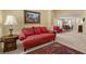 Comfortable living area featuring a red sofa, patterned rug, and view to the dining area at 2033 Summer Spruce Pl # 102, Las Vegas, NV 89134