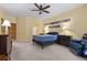 Bright main bedroom featuring neutral carpet, fan, and traditional dark wood furniture at 2033 Summer Spruce Pl # 102, Las Vegas, NV 89134