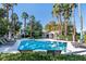 Community pool area with clear blue water, comfortable lounge chairs, and tall palm trees at 2033 Summer Spruce Pl # 102, Las Vegas, NV 89134